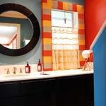 The powder bath was accented with bright colors and the window treatment in the room conceals an unsual window.